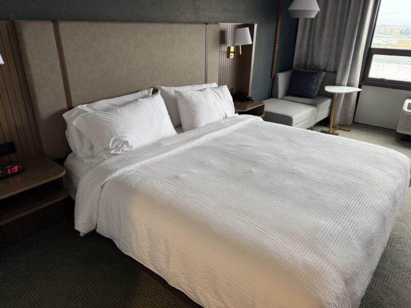 a bed with white sheets and pillows
