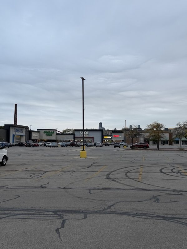 a parking lot with cars and buildings in the background