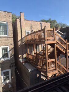 a wood staircase next to a brick building