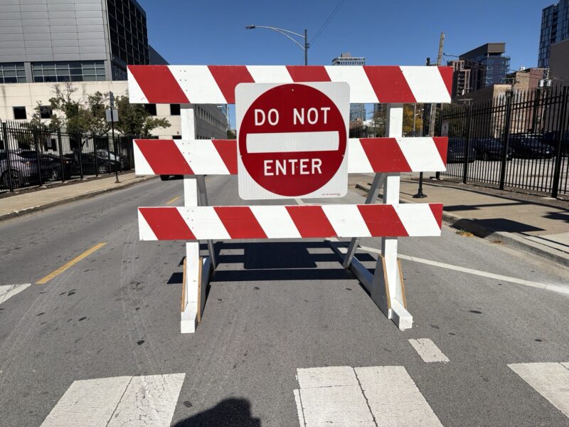 a red and white construction sign on a street