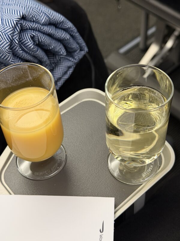 a glass of orange juice next to a glass of orange juice on a tray