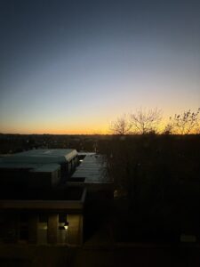 a building with trees and a sunset