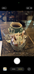 a cup of coffee and sugar packets on a table