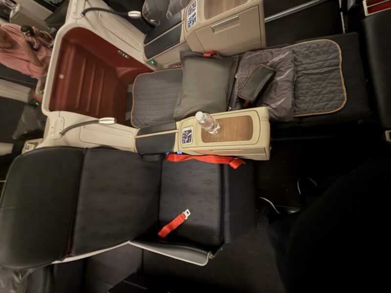 a seat with a bottle and a pillow on it