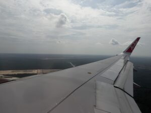 an airplane wing with a landscape in the background