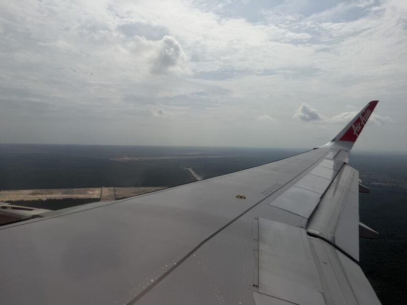 an airplane wing with a landscape in the background