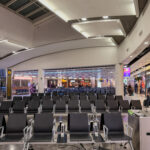 a large airport terminal with rows of chairs