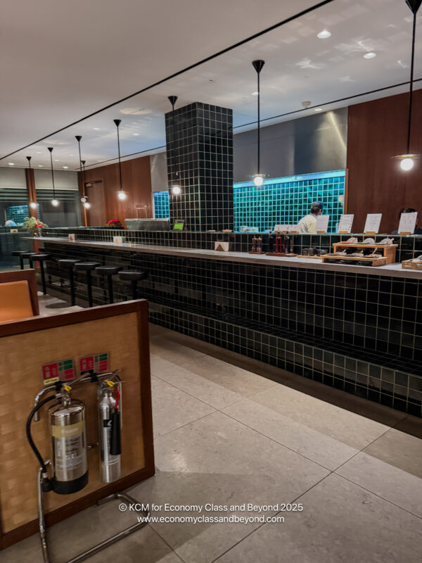 a restaurant with black tile walls and a counter