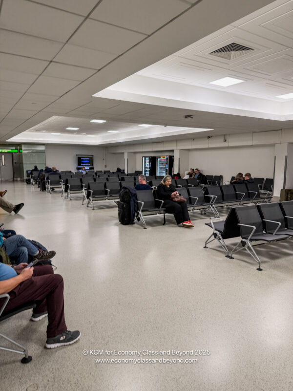 a group of people sitting in chairs in an airport