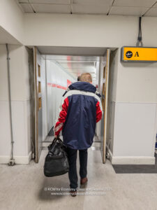 a man walking in a hallway with a bag