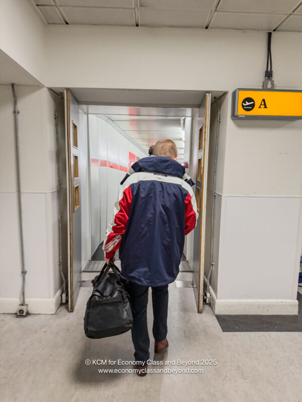 a man walking in a hallway with a bag