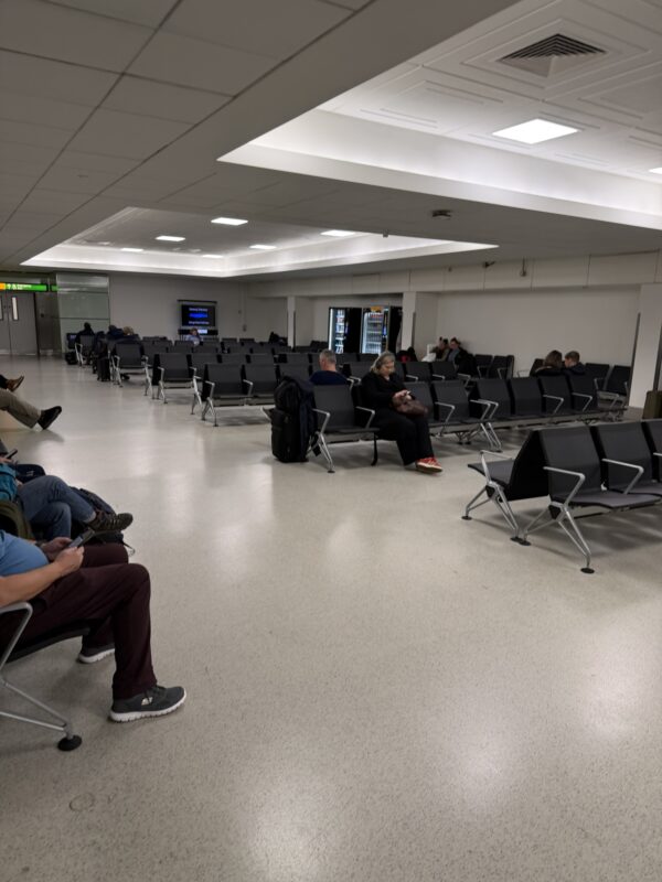 people sitting in chairs in an airport
