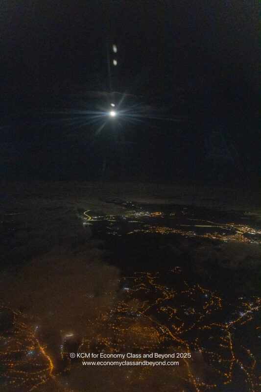 a moon over a city at night