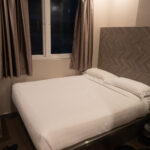 a bed with a headboard and a window