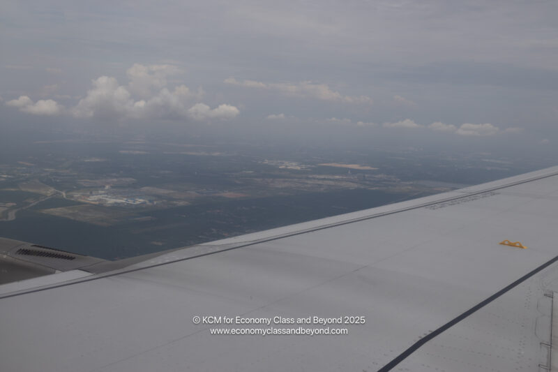 an airplane wing with a city in the background