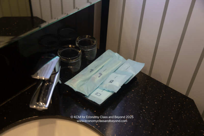 a bathroom sink with a few packets of contraceptives