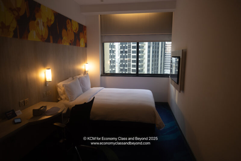 a bed in a room with a window and a view of a city