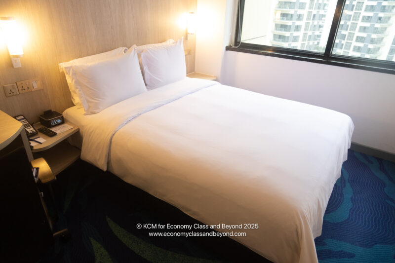 a bed with white sheets and pillows