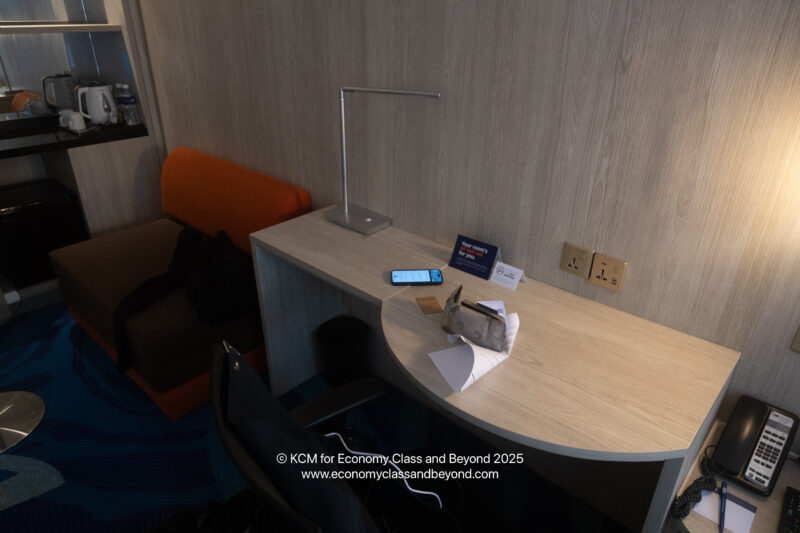 a desk with a lamp and a phone on it