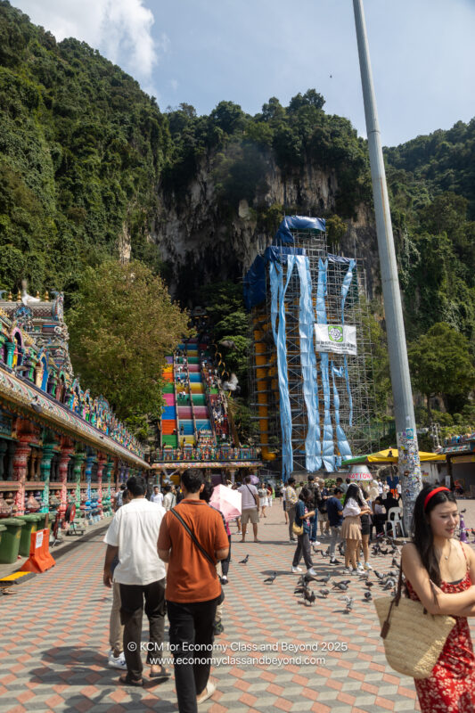 a group of people walking on a sidewalk near a building