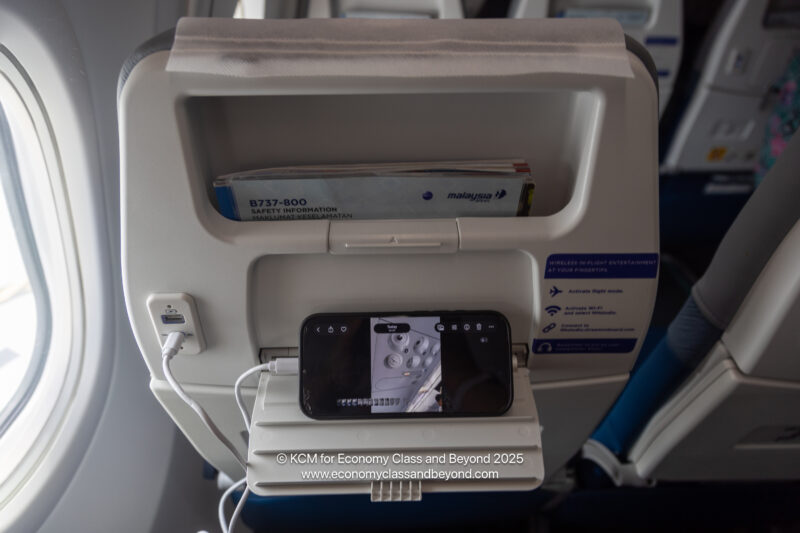 a phone charging in an airplane