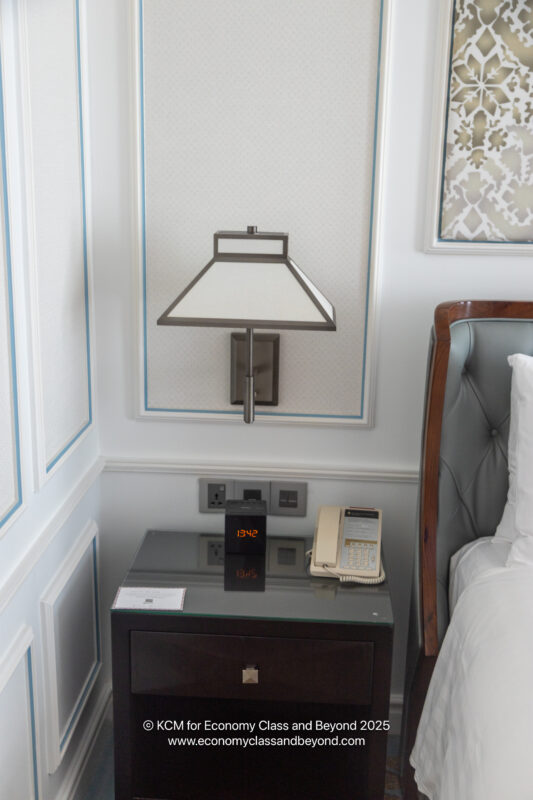 a lamp on a table next to a bed