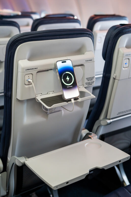 a phone charging on an airplane seat