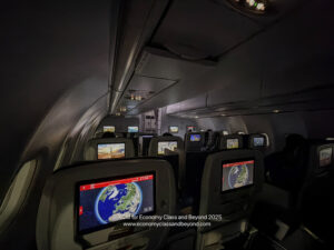 a row of seats with monitors on the back of a plane