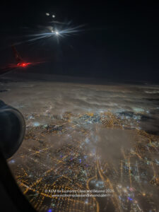 an airplane wing and lights in the sky