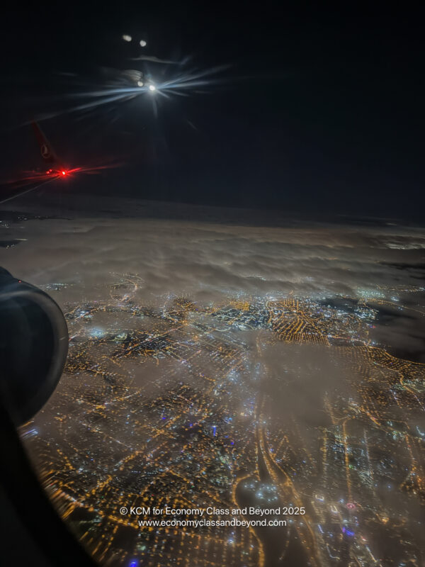 an airplane wing and lights in the sky