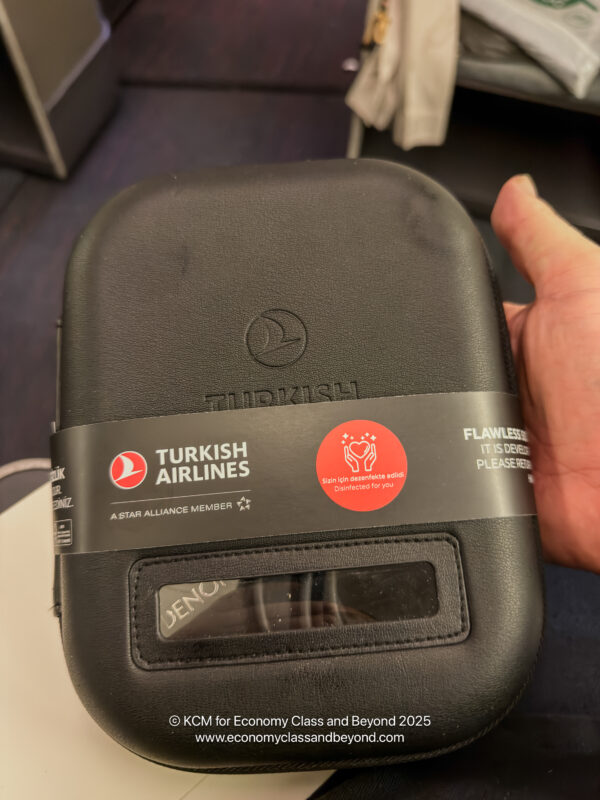 a hand holding a black rectangular object with a label