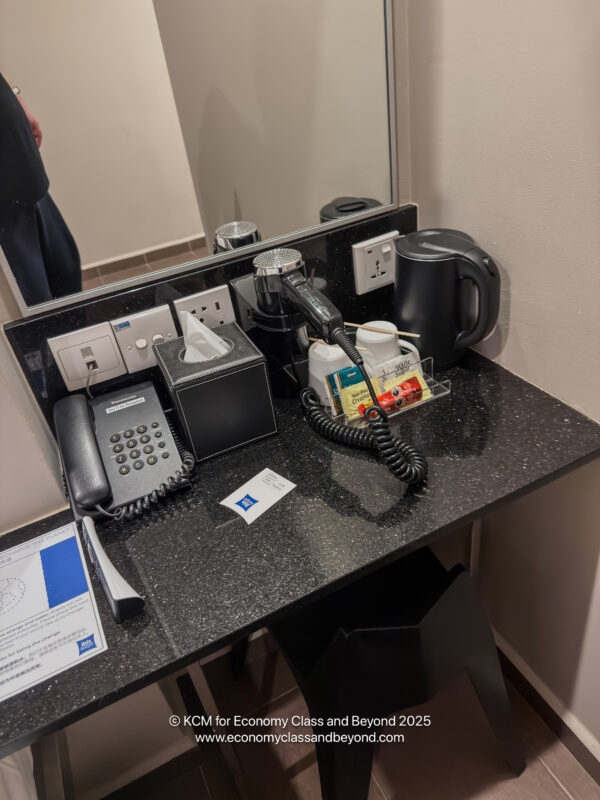 a black desk with a telephone and a coffee mug