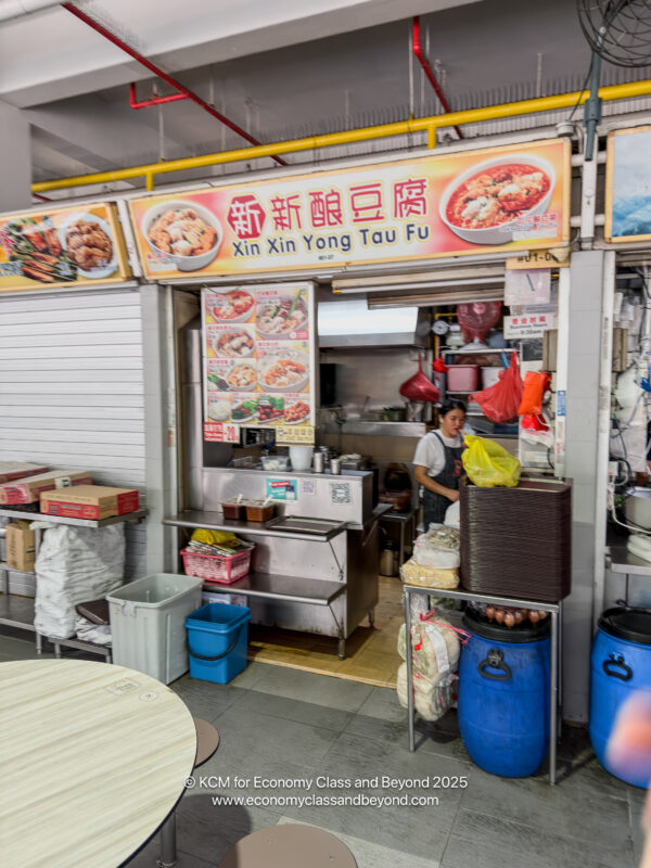 a woman standing in front of a food stand