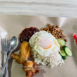 a plate of food with a fried egg and chicken wings