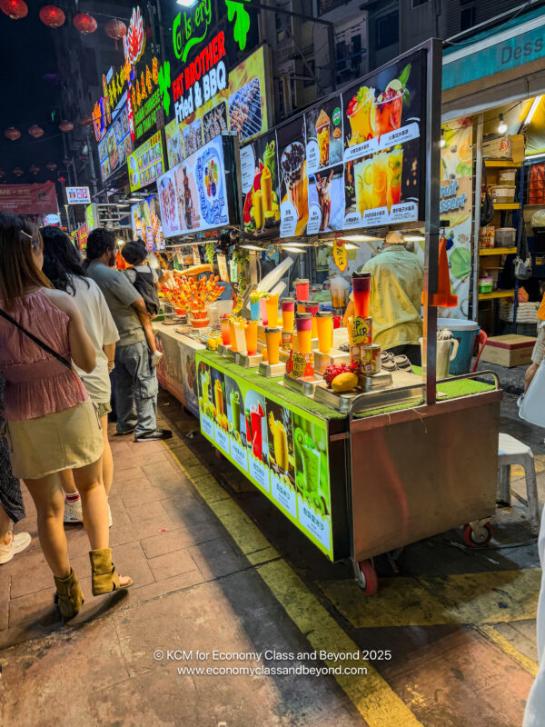 people standing in front of a food stand