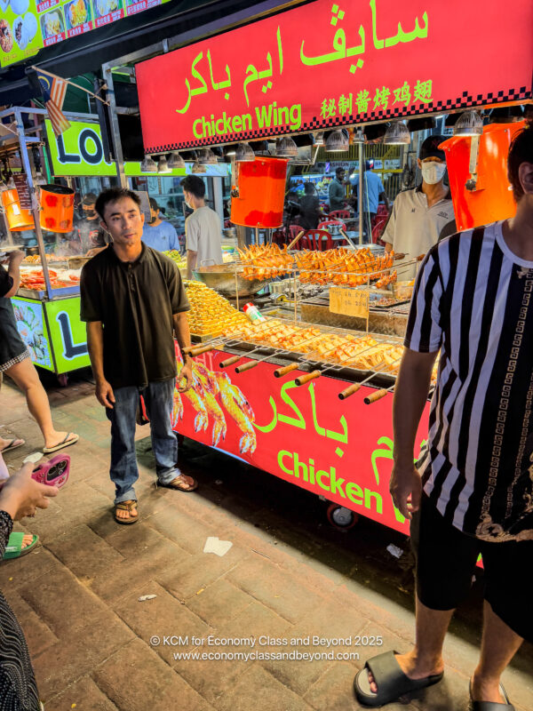 a group of people standing in front of a food stand