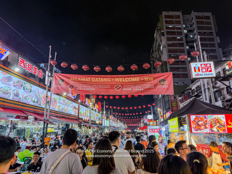 a crowd of people in a street with a banner