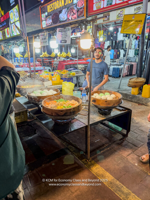 a man standing in front of a food stand