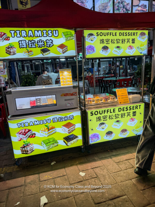 a man standing next to a food stand