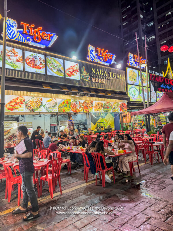 a group of people sitting at tables outside a restaurant