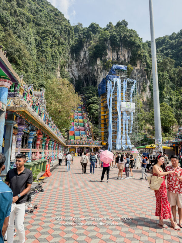 a group of people walking in a street with colorful buildings