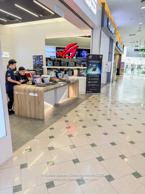 a group of people standing at a desk with laptops