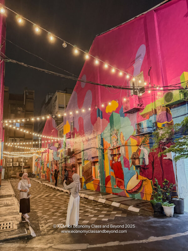 a group of people walking on a street with colorful buildings