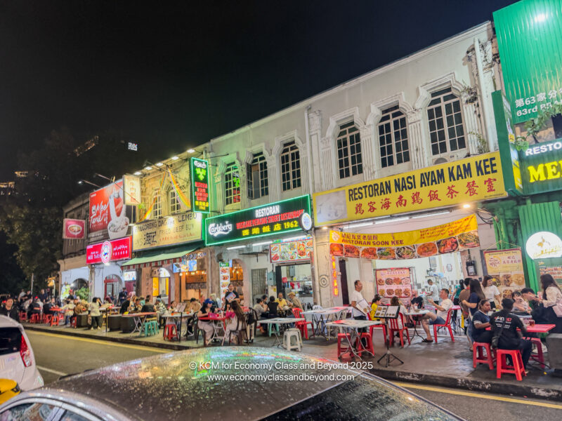 a street with people sitting at tables outside of a restaurant