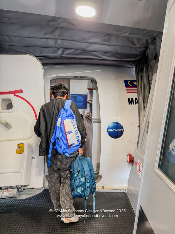 a man with a backpack walking into an airplane
