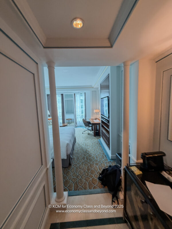 a hallway with a bed and a desk