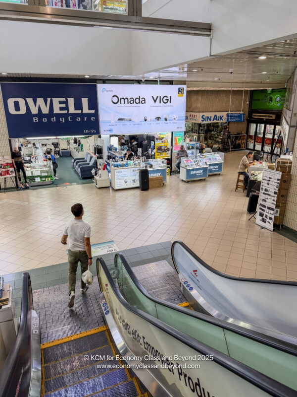 a man walking down escalator in a mall