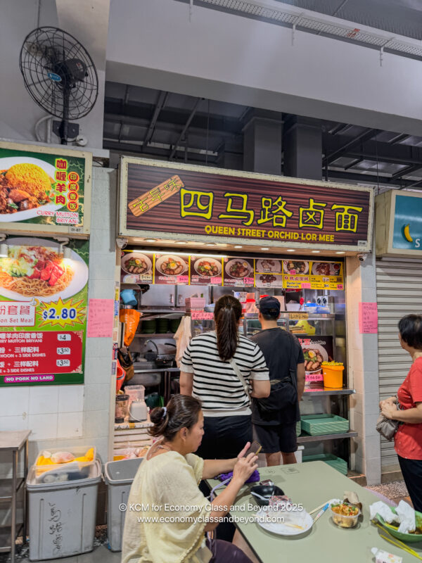 people standing in front of a food stand