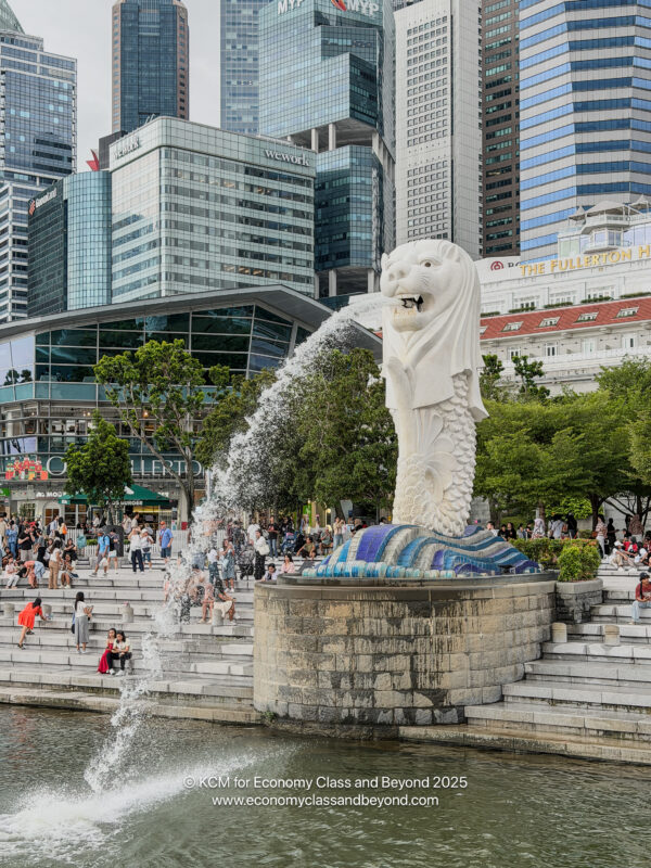a statue of a lion with a fountain in front of a city