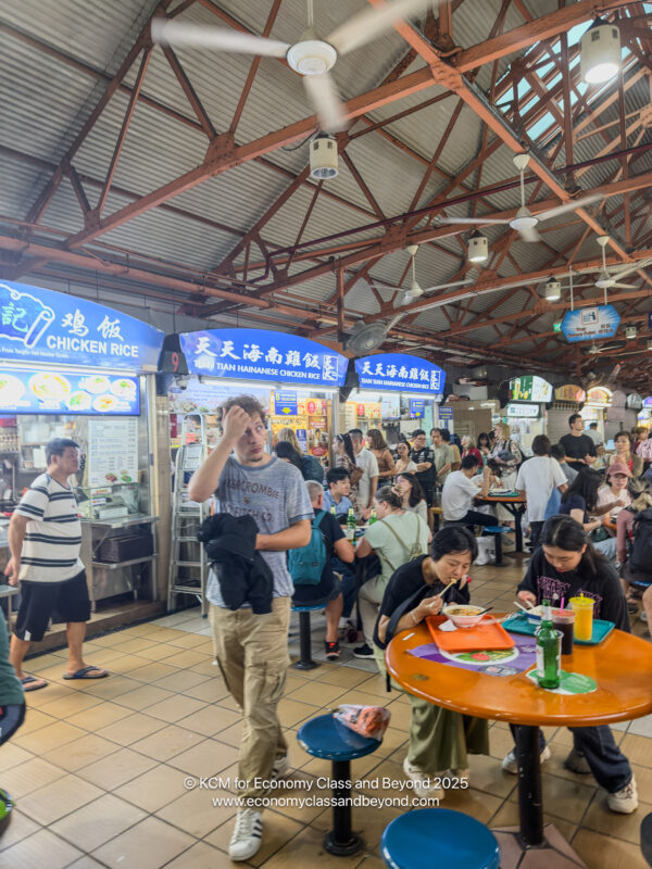 a group of people sitting at tables in a food court